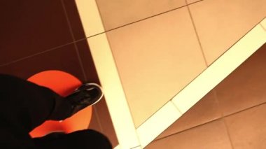 Man walks on floor with red arrows to green sign Wait here