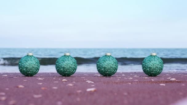 Set di palline colorate sulla sabbia bagnata contro le onde del mare sfocate — Video Stock