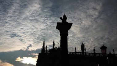 Gün batımına karşı sütun üzerinde duran aslan heykeli silueti