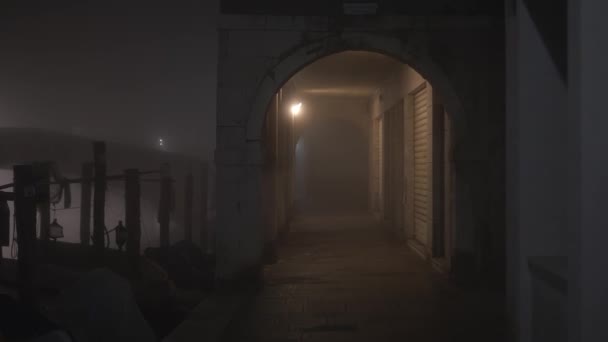 Beweging door oude smalle doorgang op dijk in mist — Stockvideo