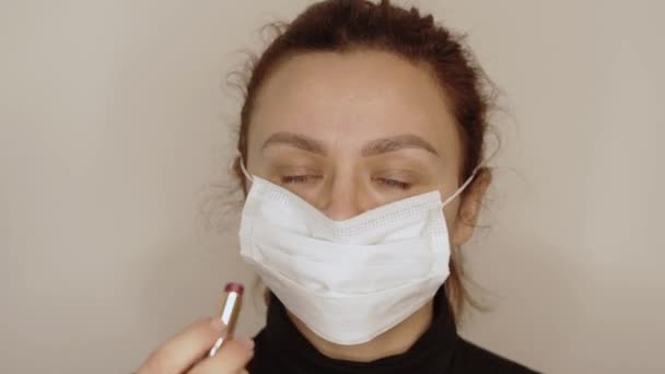 Chica pone en maquillaje de labios sobre la máscara — Vídeo de stock