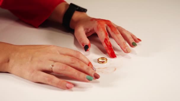 有人造血液的人的手在金戒指周围活动 — 图库视频影像