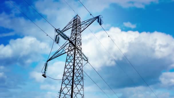 Líneas de transmisión de energía contra el cielo azul con nubes blancas — Vídeos de Stock