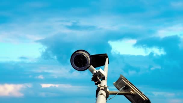 Outdoor surveillance camera and streetlights against sky — Stock Video