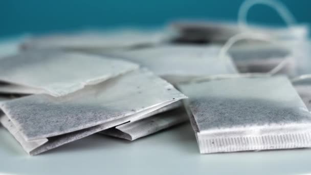 White tray with pile of numerous tea bags on light blue — Stock Video