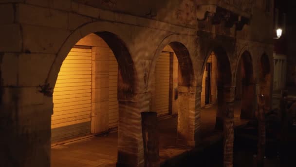 Las sombras del canal ondulan el agua en las columnas viejas por la noche — Vídeos de Stock