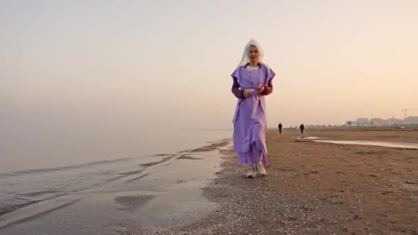 Dumna kobieta zbliża sztalugi z jasnym krajobrazem morskim na plaży — Wideo stockowe
