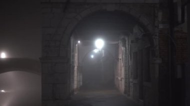 Lambayla aydınlatılan taştan sütunlarla kemer geçidi