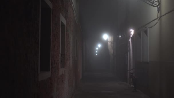 Jízdní kolo stojí u zdi budovy v osvětlené uličce — Stock video