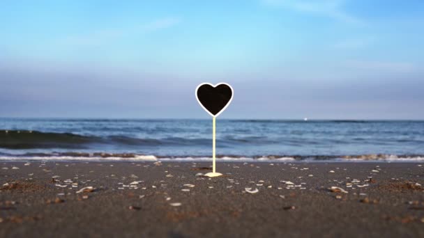 Placa de identificação em forma de coração com espaço para design na praia oceânica — Vídeo de Stock