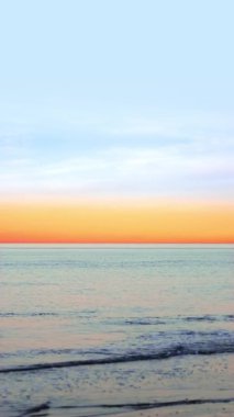 Gün batımında gökyüzüne karşı akan dalgalarla inanılmaz bir okyanus.