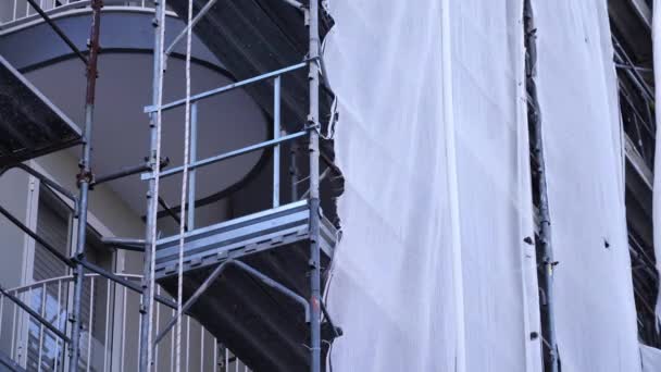 Tejido blanco desgarrado cuelga de andamios metálicos en el balcón — Vídeos de Stock