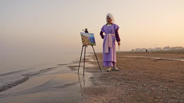 Elegancka kobieta patrząc na krajobraz morski na sztalugach umieścić na plaży morskiej — Wideo stockowe