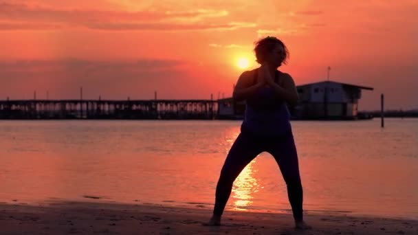 Silueta de mujer regordeta haciendo ejercicios deportivos en la playa — Vídeos de Stock