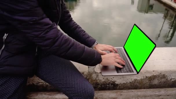 Guy lavora su laptop con schermo cromakey su ponte di pietra — Video Stock