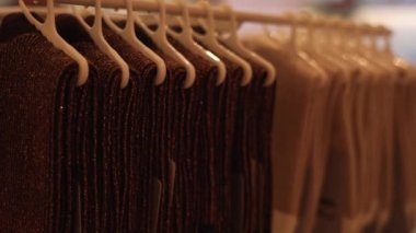 Plastik askılarda asılı el yapımı Lurex eşarplar