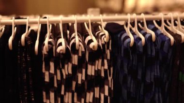 Tasarımcı damalı giysiler beyaz plastik askılarda asılı