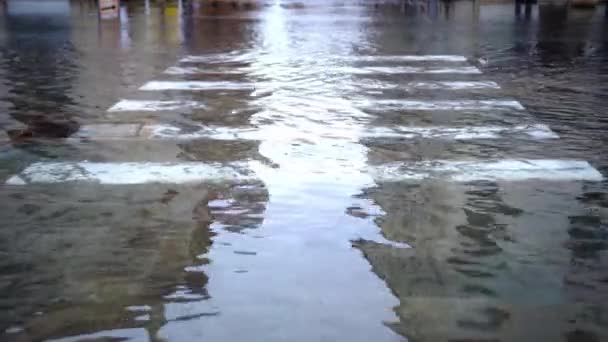 Przezroczysta woda zalewowa pokrywa szeroką drogę krzyżem — Wideo stockowe
