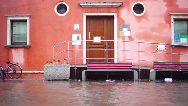 Vattenbäcken rinner längs gatan efter översvämning förbi gammalt hus — Stockvideo