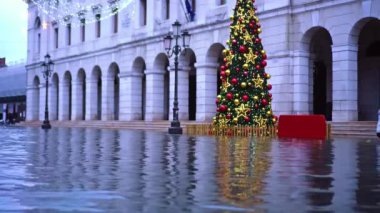 Sel basmış şehir caddesinde suya yansıyan Noel ağacı var.