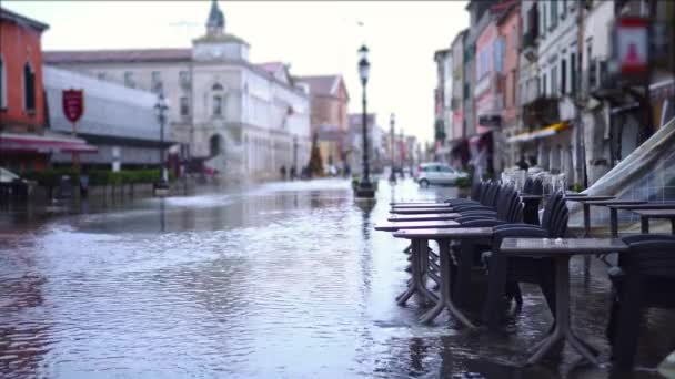 Покинуті меблі для відкритого кафе стоїть на затопленій вулиці — стокове відео