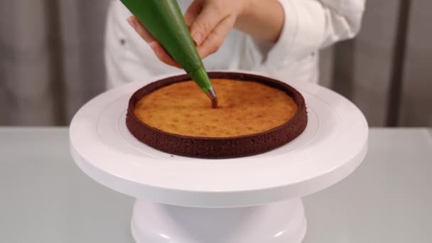 Mujer llena tarta con crema de chocolate espiral en soporte blanco — Vídeos de Stock