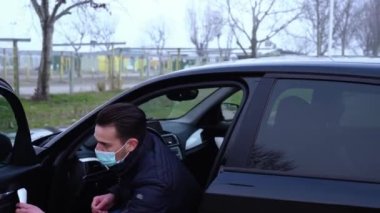 Mavi maskeli, kısa saçlı genç adam arabadan indi.