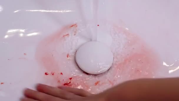 Woman hand with ring washes off blood from sink surface — Stock Video