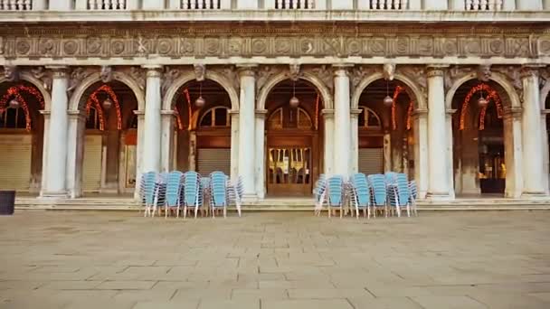 Καρέκλες και τραπέζια κοντά σε κλειστό εστιατόριο στην πλατεία του Αγίου Μάρκου — Αρχείο Βίντεο