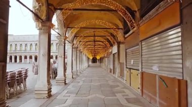 Peri ışıkları ve kapalı dükkanları olan kemer yolu boyunca hareket