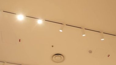 Tavanda güvenlik detektörleri olan parlayan lambalar.