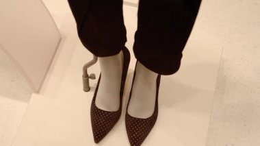 Zarif siyah kadın pantolonu ve yüksek topuklu ayakkabıları olan manken.