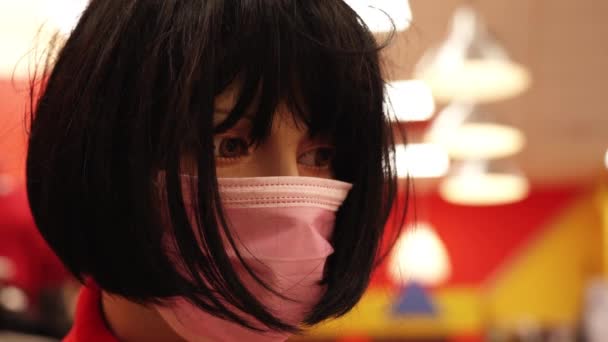 Skyltdocka med kort svart peruk och rosa mask står i beredskap — Stockvideo