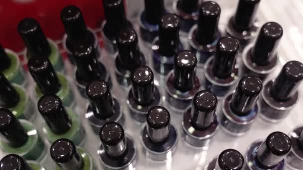 Movimiento por encima de la colección de esmaltes de uñas de colores en la tienda — Vídeos de Stock