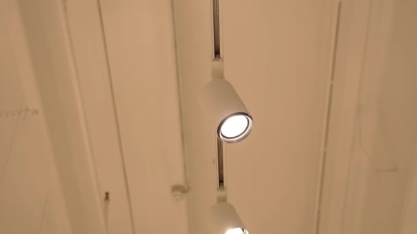 Led light point blinks hanging on rack on white ceiling — Stock Video