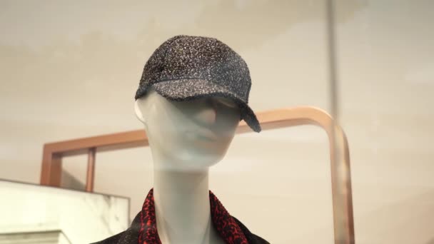 Манекен в элегантной серой женской шапочке стоит в витрине — стоковое видео