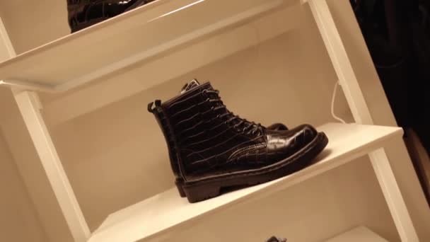 Movimiento hacia arriba a lo largo de rack con botas de mujer en la tienda de moda — Vídeos de Stock