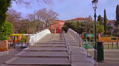 İtalya 'da dar kanalların üzerinde adımları olan modern beyaz köprü