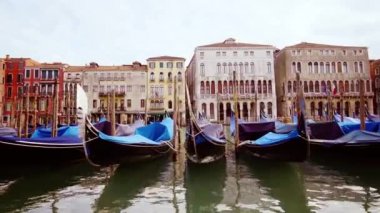 Venedik şehrinde uzun ahşap gondollar kanal suyunda sürüklenir.