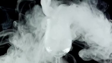 Beyaz duman cam kadehe girer.