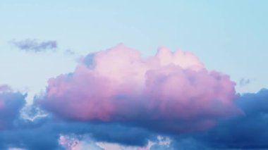Fantastik pembe ve mavi kabarık bulutlar açık gökyüzünde süzülür