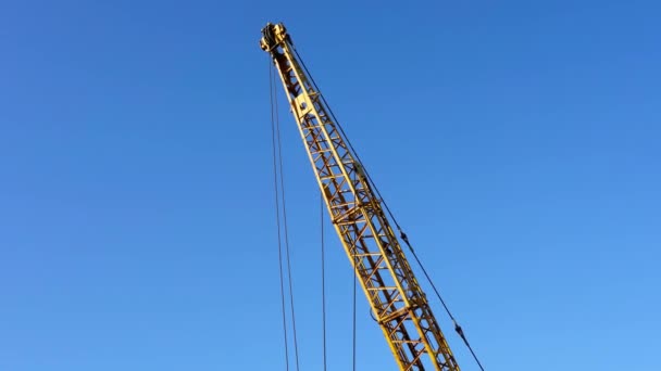 Bras de flèche de grue de camion jaune debout contre le ciel bleu — Video