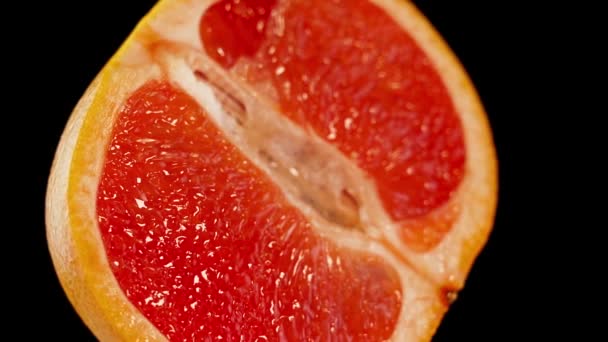 Rote Grapefruit in zwei Teile geschnitten auf schwarzem Hintergrund — Stockvideo