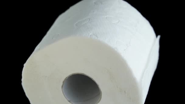 Toilettenpapier dreht sich auf isoliertem schwarzen Hintergrund — Stockvideo