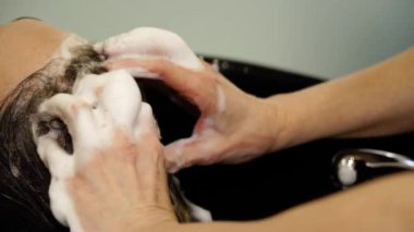 Dikkatli ol, müşteri saçlarını lavabonun üstünde şampuanla yıkar.