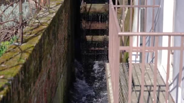 Grande roue de moulin à eau en bois obsolète tourne sur le canal — Video