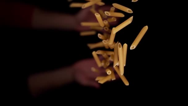 Person Hand wirft rohe gelbe Penne Nudeln Makro nach oben — Stockvideo