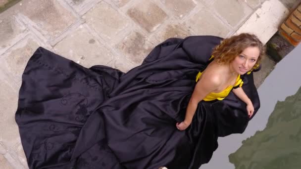 Tender lady in abito di design si siede sul parapetto canale di Venezia — Video Stock