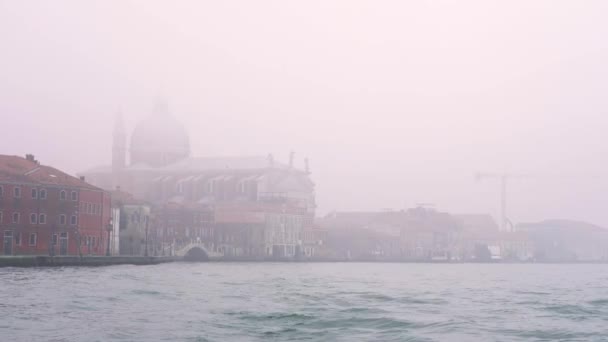 Włoskie budynki stoją w gęstej mgle nad błękitną laguną — Wideo stockowe