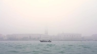 Şehir silueti, gölün kenarında duran eski binalar.